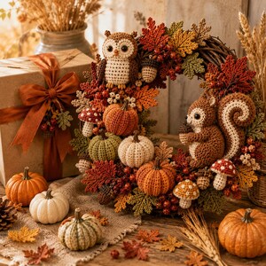 May include: A decorative autumn wreath featuring crocheted figures of an owl and a squirrel, surrounded by crocheted pumpkins, mushrooms, and fall-colored leaves. The wreath is displayed alongside a gift box with a ribbon and loose pumpkins.