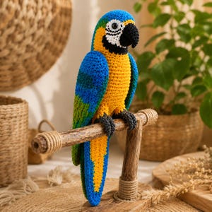May include: A crocheted macaw parrot figurine featuring vibrant blue, yellow, and green yarn. The bird has a black beak, white facial patches, and dark grey feet, perched on a horizontal wooden stand with wrapped rope accents at the joints.