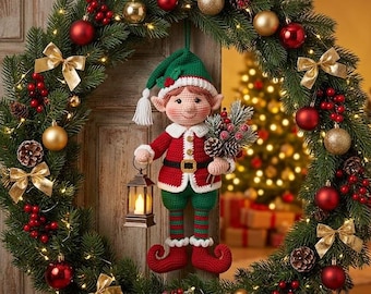 May include: A crocheted elf doll wearing a red and green outfit with a matching hat, holding a small lantern and a pine branch, suspended in the center of a large evergreen Christmas wreath decorated with red and gold ornaments.