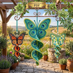 May include: Three hanging crochet butterfly ornaments with spiral tails. The left is orange and black, the center is teal and green with peacock-like eye patterns, and the right is light green and white. A banner at the top reads TÉLÉCHARGEMENT PDF.