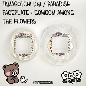 May include: Two clear Tamagotchi Uni faceplates with a Gomgom Among The Flowers design. One faceplate is assembled, the other is separate. The design features a bear, flowers, and text. A cartoon bear holding a flower and a duck are in the lower left corner.