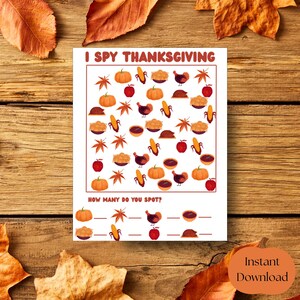 Könnte beinhalten: Eine weiße Spielkarte zum Thema Thanksgiving mit dem Text "I Spy Thanksgiving". Die Karte zeigt Illustrationen von Kürbissen, Äpfeln, Mais, Truthahn, Kuchen und Blättern. Der Satz "How many do you spot?" steht unten. Ein orangefarbener Kürbis mit den Worten "Instant Download" befindet sich in der Ecke.