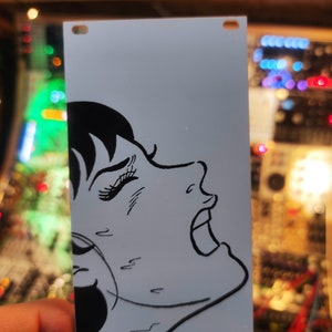 Puede incluir: Una ilustración en blanco y negro de la cara de una mujer con una expresión de sorpresa. La ilustración está impresa sobre un fondo azul claro.