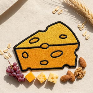 May include: Embroidered cheese wedge patch in yellow with black outline and oval holes. The patch is surrounded by grapes, nuts, and various cheese cubes. A sprig of wheat and oats are also present.