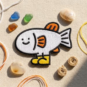 May include: A white ceramic mug with a black handle and the text "But First, Coffee" in a black, handwritten-style font. The mug is on a white surface.