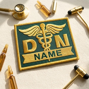 May include: A green and gold embroidered patch with the text "D N NAME" and a caduceus symbol. The patch is surrounded by medical tools, including a stethoscope, reflex hammers, and vials.