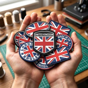 May include: A collection of rubberized patches featuring the Union Jack flag in red, white, and blue. The patches include various shapes like shields, circles, and rectangles with text such as UNITED KINGDOM, LONDON ENGLAND, and MADE IN UK printed on them.