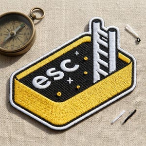 May include: A white ceramic mug with a black handle and the text "But First, Coffee" in a bold, black font. The mug is set against a blurred background, suggesting a cozy setting.