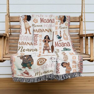 a woven blanket with various Moana characters and designs, including Moana, Moana, Moana, and Moana, printed on it.