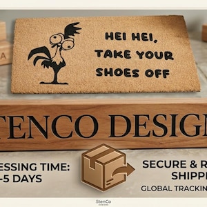 Puede incluir: Un felpudo rectangular de fibra de coco color canela con un gr&aacute;fico negro de un pollo de dibujos animados y el texto "HEI HEI, TAKE YOUR SHOES OFF". Frente a la alfombra hay un bloque de madera rectangular con el texto "STENCO DESIGNS".
