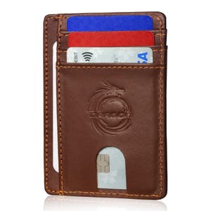 May include: A brown leather cardholder with orange stitching. The cardholder has a dragon logo and holds several credit cards in red, blue, and white. The cardholder has a slot for easy card access.