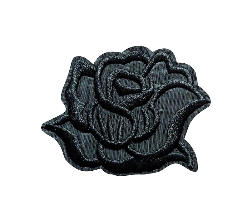 Puede incluir: Parche de rosa bordada en negro. El parche presenta un dise&ntilde;o detallado de una flor de rosa con p&eacute;talos y hojas texturizadas. Probablemente sea para fines decorativos, como agregar a ropa o accesorios.