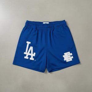 Può includere: Pantaloncini in rete blu reale con loghi bianchi "LA" ed "E". I pantaloncini hanno un elastico in vita e una vestibilità rilassata. Il tessuto è traspirante, adatto per lo sport o l'abbigliamento casual.