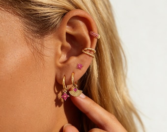 Conjunto de brincos empilháveis com zircônias cúbicas rosa-avermelhadas, banhados a ouro, estilo ear cuff, com argolas e pingentes. Ideal para festas e eventos femininos.