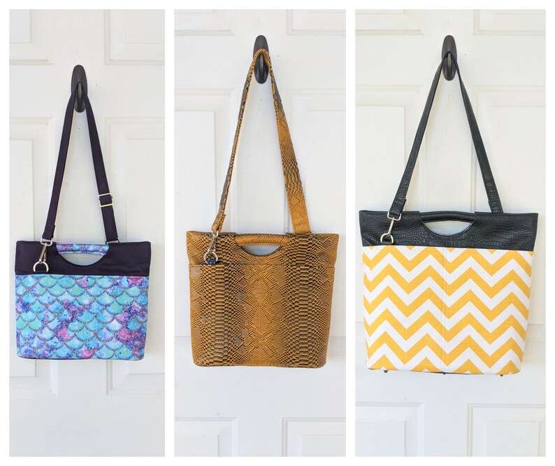 May include: Three different tote bags hanging on hooks. The bag on the left has a blue and purple mermaid scale pattern. The middle bag is brown with a snakeskin pattern. The bag on the right has a black and yellow chevron pattern.
