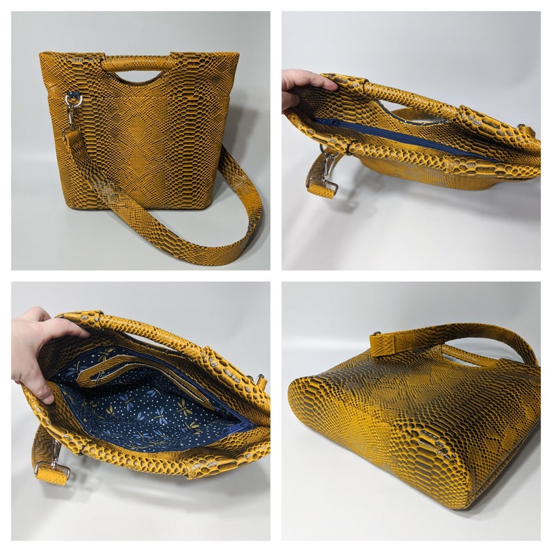 May include: A yellow snakeskin-patterned handbag with a top handle and a long shoulder strap. The bag has a zipper closure and a blue and white patterned lining.