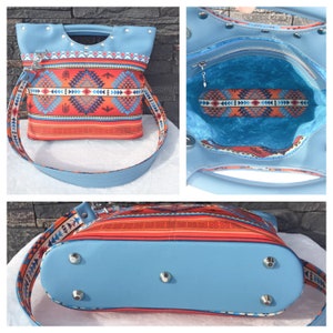 May include: A blue and red patterned tote bag with a top handle and a long shoulder strap. The bag has a zippered pocket on the inside and metal feet on the bottom.