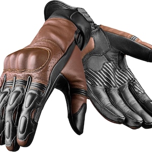 May include: A pair of brown and black motorcycle gloves. The gloves feature brown leather on the back of the hand and black leather on the palm and fingers. The gloves have padded knuckles and ventilation holes. The palm has a striped design.