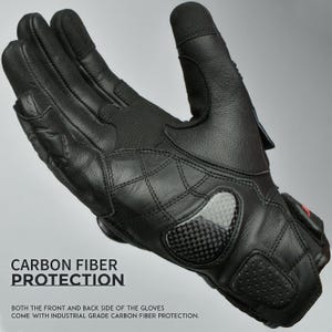 May include: Black motorcycle gloves with carbon fiber protection. The gloves have a quilted design on the back and a carbon fiber panel on the knuckles. The text "CARBON FIBER PROTECTION" is visible.