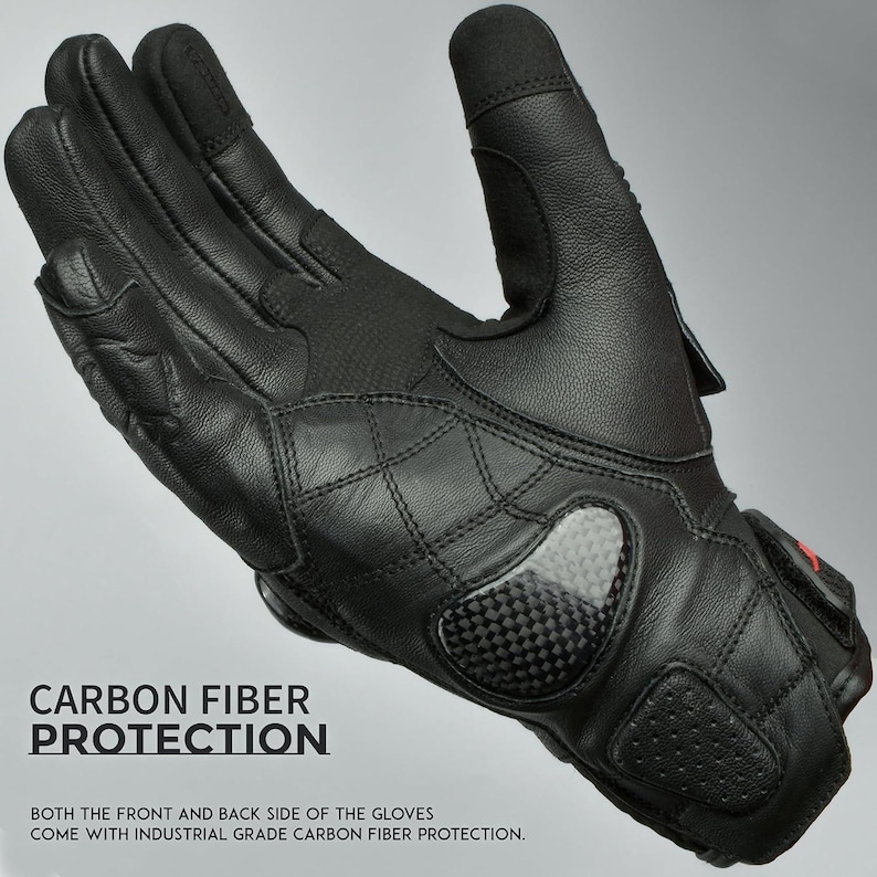 May include: Black motorcycle gloves with carbon fiber protection. The gloves have a quilted design on the back and a carbon fiber panel on the knuckles. The text "CARBON FIBER PROTECTION" is visible.
