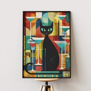 Pode incluir: Uma impressão artística emoldurada com um gato preto estilizado com olhos verdes, rodeado por taças de cocktail. O fundo tem um design geométrico com cores vermelha, amarela, azul e verde. A obra de arte é exibida em um banco de madeira.