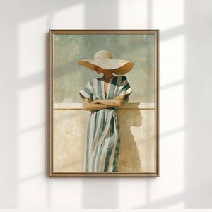 May include: Framed art print featuring a person wearing a wide-brimmed hat and a blue and white striped dress. The artwork has a vintage aesthetic, with a neutral color palette and a focus on light and shadow. The frame is gold.