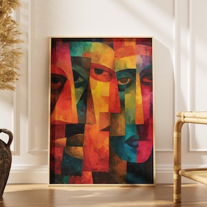 Puede incluir: Impresión artística abstracta con un collage de rostros en colores vibrantes. La obra de arte utiliza una paleta de rojo, naranja, amarillo, verde y azul. La pieza enmarcada se exhibe sobre un suelo de madera, junto a un jarrón con plantas secas.