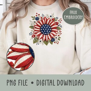 May include: A beige crewneck sweatshirt featuring a central graphic of a sunflower with red and white striped petals and a blue center with white stars, surrounded by small flowers and leaves. A circular inset shows a close-up of the texture.