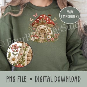 Op de afbeelding: Een olijfgroen sweatshirt met een centrale afbeelding van een paddenstoelvormig huis met een rode hoed, een houten deur en ramen. Het ontwerp is omringd door bloemen, wijnranken en vlinders, met een cirkelvormig inzetstuk voor een detailweergave.