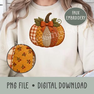 May include: A cream-colored sweatshirt featuring a central pumpkin graphic with faux embroidery. The pumpkin is composed of various orange, brown, and tan fabric patterns, including gingham, houndstooth, and floral prints, topped with a bow.