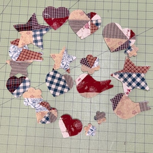 May include: A collection of fabric shapes including hearts, stars, birds, and small flowers. The pieces feature various patterns such as red and white gingham, blue and white plaid, and floral prints in shades of red, blue, beige, and brown.