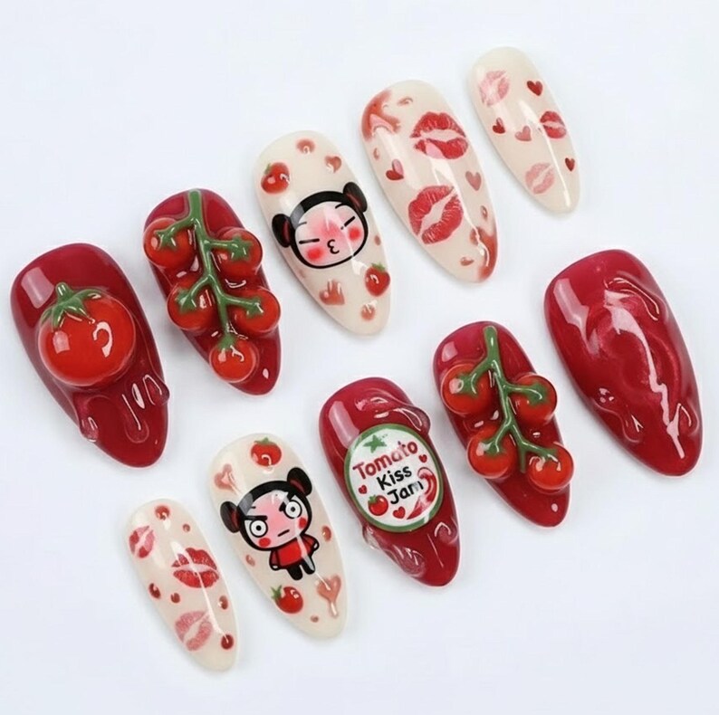 K&ouml;nnte beinhalten: Eine Sammlung k&uuml;nstlicher N&auml;gel mit verschiedenen Designs. Einige N&auml;gel zeigen 3D-Tomaten, Tomatenranken und Zeichentrickfiguren. Andere zeigen rote Lippen und Herzmuster. Die N&auml;gel sind in Rot-, Wei&szlig;- und Beiget&ouml;nen lackiert.