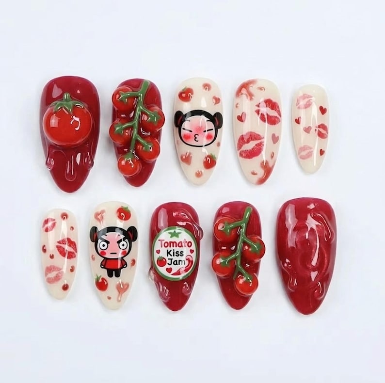 K&ouml;nnte beinhalten: Ein Set aus zehn k&uuml;nstlichen N&auml;geln mit verschiedenen Designs. Die N&auml;gel zeigen roten, wei&szlig;en und klaren Nagellack mit 3D-Tomaten, Lippenabdr&uuml;cken und einer Cartoonfigur. Ein Nagel tr&auml;gt den Text "Tomato Kiss Jam".