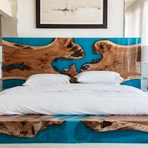 Può includere: Camera da letto moderna con un letto con testiera e pediera uniche. La testiera e la pediera sono in legno con un intarsio in resina turchese. La biancheria da letto bianca e le lampade da comodino bianche completano l'arredamento.