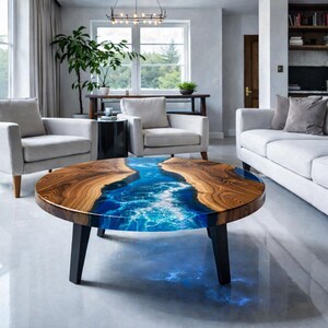 May include: Round coffee table with a unique design. The table features a wooden top with a river-like blue epoxy resin center. It has black legs and is placed in a modern living room setting.