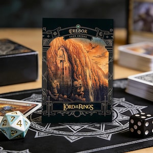 May include: A card featuring the Erebor illustration from The Lord of the Rings. The card has a dark green border with gold accents and the text "EREBOR" at the top. The image depicts a mountain with a large entrance and a sunset in the background.