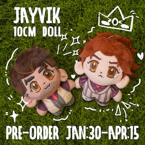 May include: Two plush dolls, each approximately 10 cm tall, with detailed facial features and outfits. The dolls have brown and auburn hair, and are set against a green background. Text on the image reads "JAYVIK 10CM DOLL" and "PRE-ORDER JAN:30-APR:15."