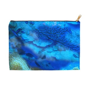 May include: A blue and white zippered pouch with a colorful underwater scene featuring coral, fish, and a blue and white fish.