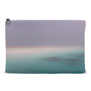 Op de afbeelding: Een zachte, lichtpaarse en blauwe gradiëntachtergrond met een witte lijn die de kleuren scheidt. De onderste helft van de afbeelding is lichtblauw, turquoise en teal van kleur, wat lijkt op een kalme oceaan.