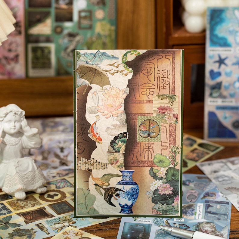 May include: A decorative card with a collage of Asian-inspired imagery. The design includes a blue and white vase, koi fish, lotus flowers, and traditional calligraphy. The card has a green border and a torn paper effect.