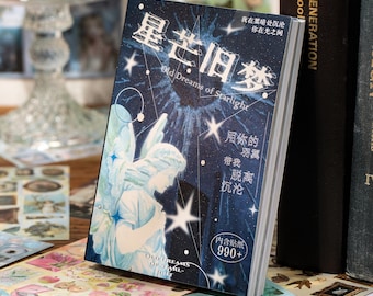 May include: A decorative sticker book with a celestial theme. The cover features an illustration of an angel, stars, and the text "Old Dreams of Starlight" in English and Chinese characters. The book is surrounded by other stickers.