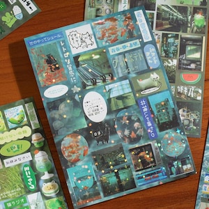 May include: A collection of decorative stickers with a teal and blue color scheme. The stickers feature various images, including fish, buildings, and Japanese text. Some stickers have a glittery finish, adding a touch of sparkle. The overall theme is a mix of retro and modern aesthetics.