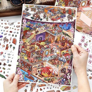 Könnte beinhalten: Detaillierte, farbenfrohe Illustration einer Fantasiewelt mit verschiedenen Räumen und Charakteren. Das Bild enthält einen Drachen, Geister und andere skurrile Elemente. Das Kunstwerk wird von einer Person gehalten, mit zusätzlichen Aufkleberbögen sichtbar.