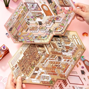 May include: Two hexagonal paper cutouts showing detailed bakery scenes. The top cutout depicts a pink-themed bakery with pastries and a "Baking Room" sign. The bottom cutout displays a brown-toned bakery with various breads and seating areas.
