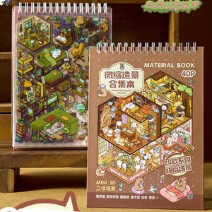 Puede incluir: Dos libros de material con espiral con ilustraciones coloridas. El libro de la izquierda presenta una vista isométrica detallada de una habitación con muebles y plantas. El libro de la derecha tiene texto en japonés e inglés, con una escena ilustrada similar.