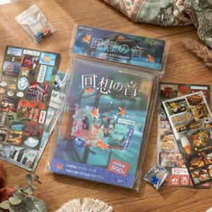 May include: A collection of Japanese stickers and sticker books. The main sticker book is in a clear plastic package with Japanese text and illustrations of goldfish. Other stickers feature various images and Japanese text. Small bags of colorful items are also present.