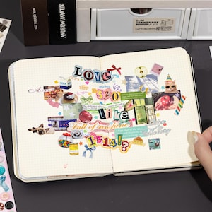 Puede incluir: Un cuaderno de cuadr&iacute;cula abierto que presenta un collage de varias pegatinas y recortes, incluyendo textos que dicen Love, 520, like, 1314, Full of sunshine y Listen to the song, junto a im&aacute;genes de gatos, frutas, comida y elementos decorativos.