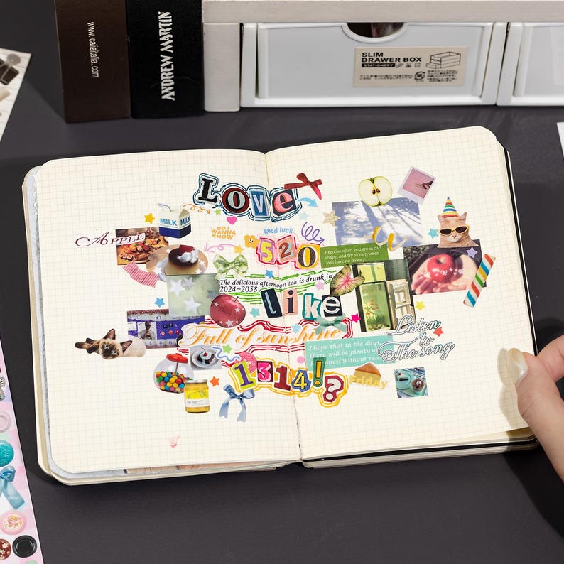 Puede incluir: Un cuaderno de cuadr&iacute;cula abierto que presenta un collage de varias pegatinas y recortes, incluyendo textos que dicen Love, 520, like, 1314, Full of sunshine y Listen to the song, junto a im&aacute;genes de gatos, frutas, comida y elementos decorativos.