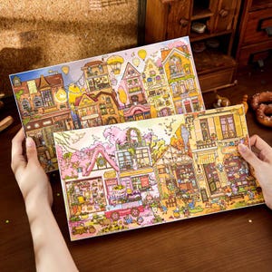 Pode incluir: Duas recortes de papel ilustrados e coloridos de paisagens urbanas europeias. O recorte superior apresenta edifícios em tons de amarelo, laranja e castanho. O recorte inferior mostra edifícios rosa e verdes, com uma floricultura. Balões de ar quente flutuam no céu.