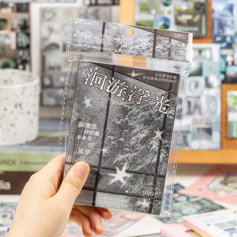 May include: A clear plastic package containing a set of stickers. The stickers feature a grayscale image of a snowy forest scene with the text "Migratory Floating Light" and other Chinese characters. The package also includes the text "30PA" and "990+".